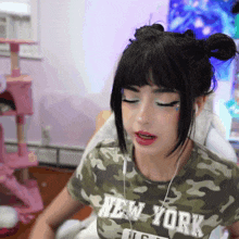 a woman wearing a new york t-shirt is sitting in a chair