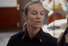 a woman in a police uniform has her eyes closed