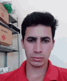 a man wearing a red shirt is making a funny face in front of a box that says diluente
