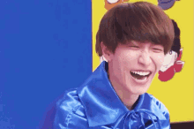 a young man wearing a blue cape is laughing