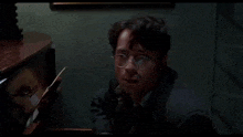 a man is reaching into a dresser drawer with a piece of paper in it