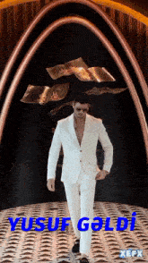 a man in a white suit stands in front of a sign that says xefx