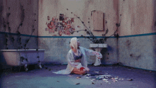 a woman is sitting on the floor in a bathroom