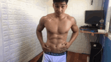 a shirtless man is standing in a room wearing a pair of underwear that says jack & jones on the waistband
