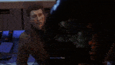 a man in a suit is talking to venom who is looking at him