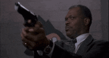 a man in a suit is pointing a gun at something