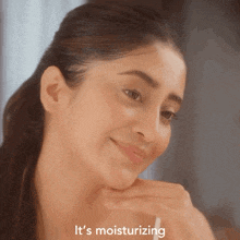 a close up of a woman 's face with the words it 's moisturizing above her