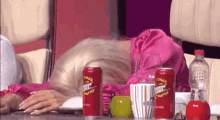 a woman in a pink dress is sitting at a table with a can of pringles on it .