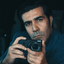 a man holds a sony camera in his hands