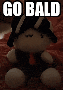 a teddy bear is laying on a bed and says go bald