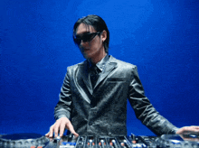 a man in a leather jacket is playing music on a turntable