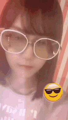 a woman wearing sunglasses and a smiley face behind her .