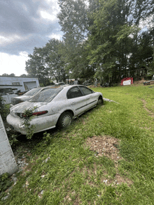 a white car is parked in a grassy area with other cars