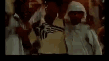 a group of people are standing next to each other in a room in a movie .