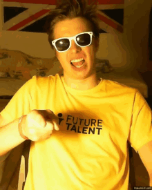 a man wearing sunglasses and a yellow shirt that says future talent on it