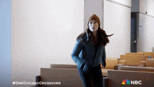 a woman standing in a room with a nbc logo