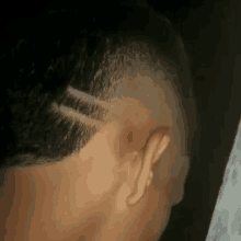 a close up of a man 's head with a shaved design in it .