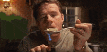 a man is eating butter with a spoon with a flame in his mouth .