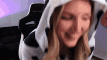 a woman wearing a cow costume is sitting in a chair and making a funny face .