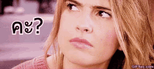 a woman in a pink sweater is making a funny face and looking up .