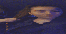a woman is taking a selfie in a dark room with a blue light behind her .
