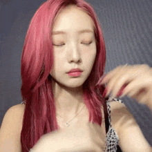 a woman with red hair is making a funny face with her eyes closed while wearing a necklace .