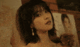 a woman leaning against a wall with a picture of a woman in the background