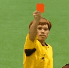 a man in a yellow shirt is giving a thumbs up to another man .
