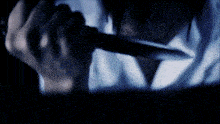a blurry image of a person holding a knife in their hand