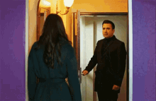 a man and a woman are standing in a doorway .