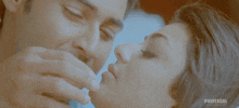 a man and woman are kissing in front of a universal sign