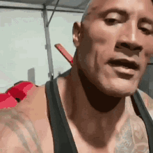 a close up of a man 's face with a black tank top