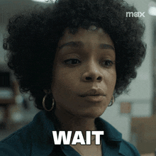 a woman with curly hair and hoop earrings says " wait "