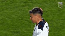 a soccer player with a shaved head is running on the field