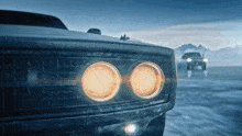 a close up of a car 's headlights with a mountain in the background