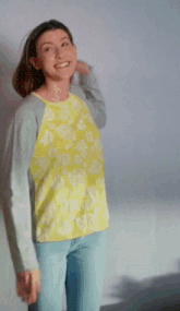 a woman in a yellow top is laughing and holding a piece of paper