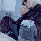 a person smoking a cigarette while wearing a purple robe
