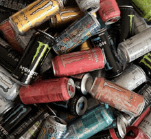 a pile of monster energy drinks including juicy monster