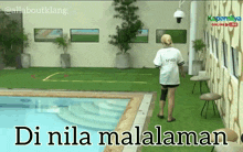 a woman in a white shirt with the word mmd on it walks near a pool