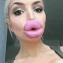 a close up of a woman 's face with huge pink lips .