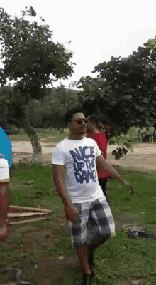 a man wearing a nice up the dance shirt is dancing in a park