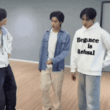 a man wearing a hoodie that says " elegance is refusal "