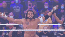 a man in a shirt that says hardest worker is standing in a wrestling ring