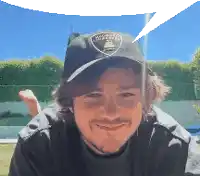 a man wearing a lamborghini baseball cap is smiling
