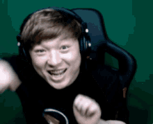 a young man wearing headphones and a black shirt with a circle on it