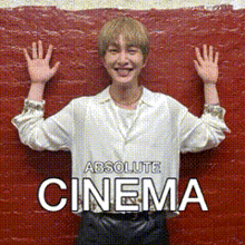 a man in a white shirt is standing in front of a red wall with his hands in the air and the words absolute cinema below him