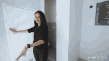 a woman is standing in a room with the words made in animatica on the bottom right