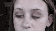 a close up of a young woman 's face with her eyes closed