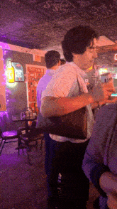 a man holding a purse in a room with a sign that says superland shine on it