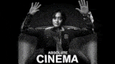 a black and white photo of a woman sitting in a chair with her arms outstretched with the words absolute cinema below her